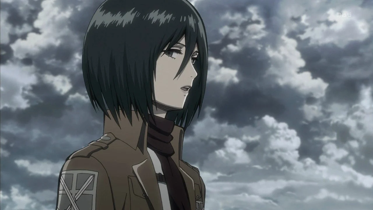 Mikasa Ackerman, son écharpe autour du cou, sous un ciel nuageux dans L'Attaque des Titans