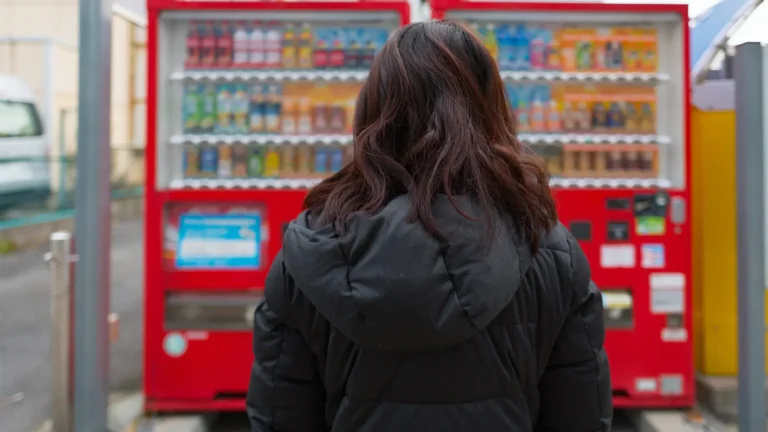 Une femme japonaise devant un distributeur automatique au Japon