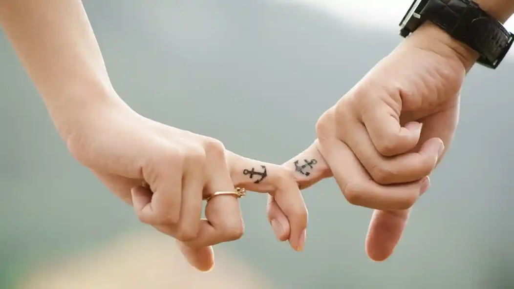 Deux mains qui se croisent avec des tatouages