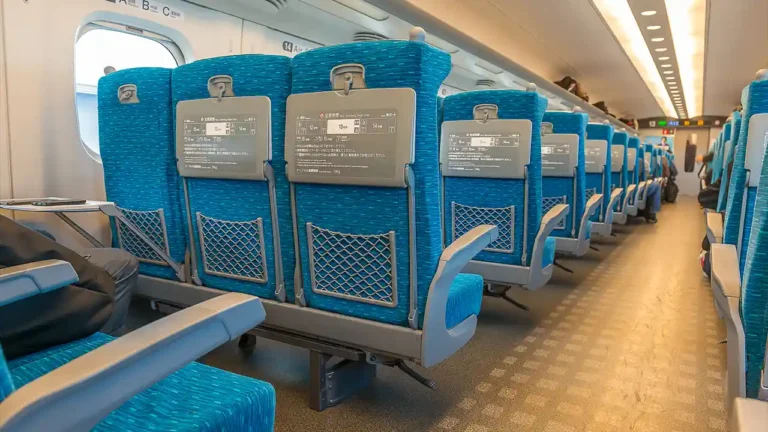 Photographie de l'intérieur d'un train Shinkansen au Japon, avec des sièges bleus