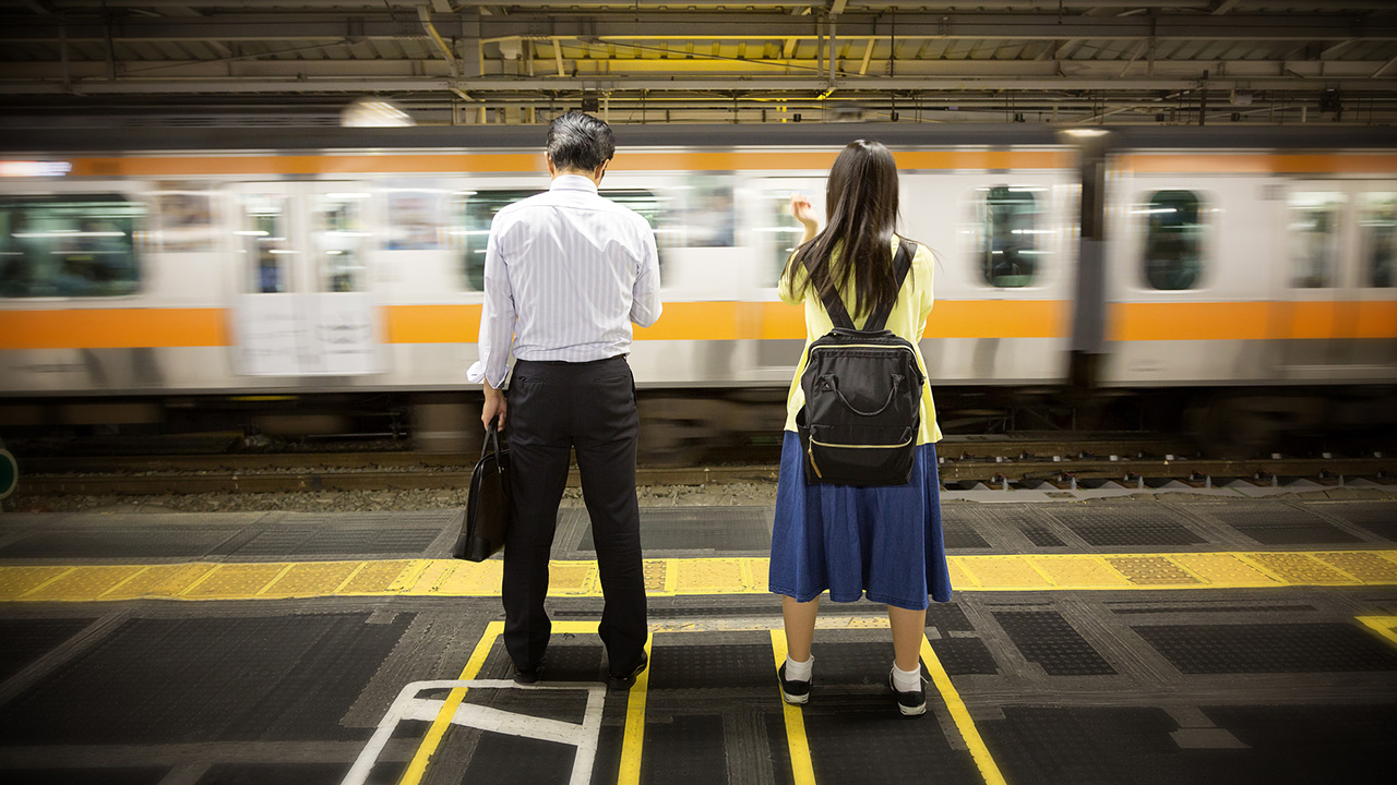 Deux Japonais qui attendent le train dans une gare