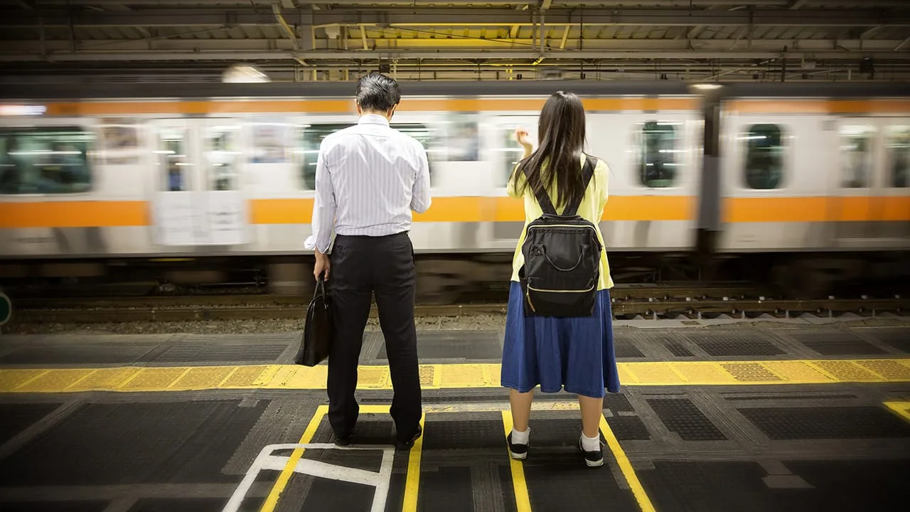 Deux Japonais qui attendent le train dans une gare