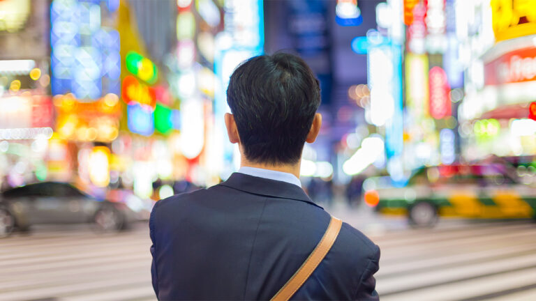 Un Japonais, de dos, regarde une rue de Tokyo