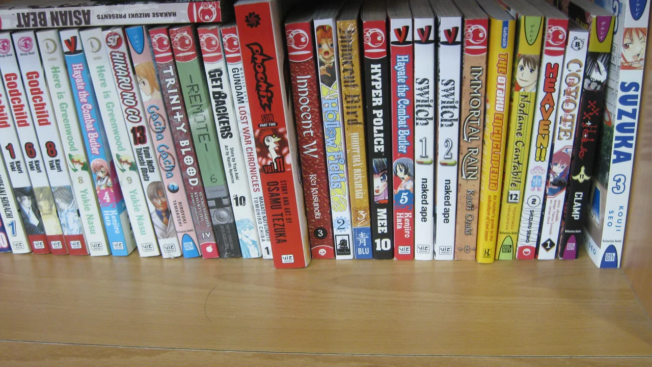 Tranches de mangas alignées dans une bibliothèque, avec plusieurs séries et numéros lisibles