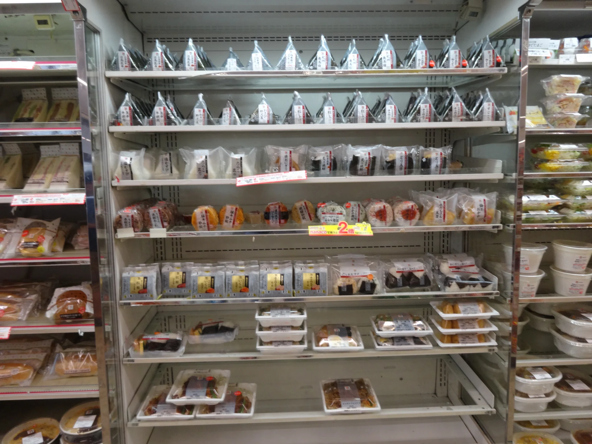 Rayon de produits frais d’un konbini japonais avec onigiri, sandwichs et repas préparés