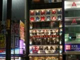 Façade d’un restaurant de Tokyo la nuit, couverte d’enseignes lumineuses en kanji et en katakana