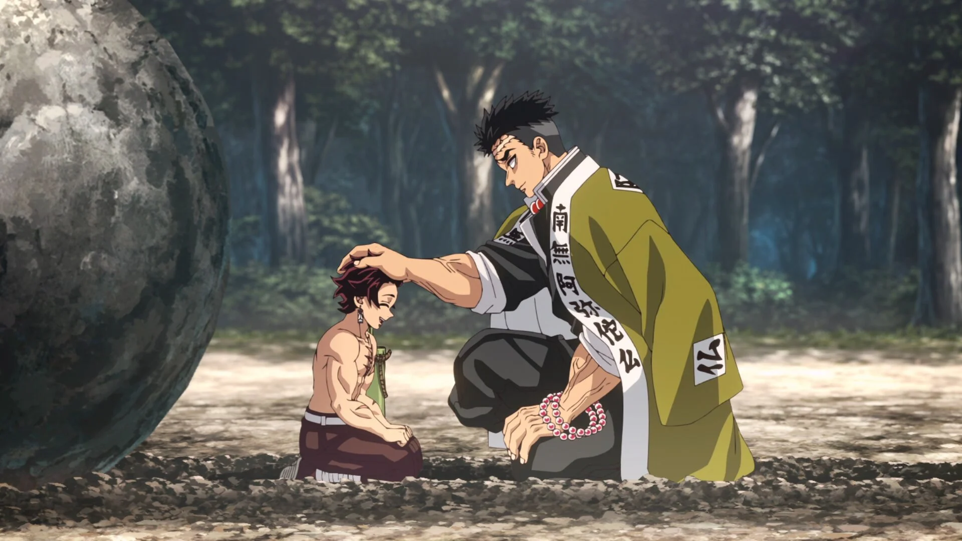 Gyomei Himejima pose la main sur la tête de Tanjiro, à côté d’un énorme rocher, pendant l’Entraînement des Piliers