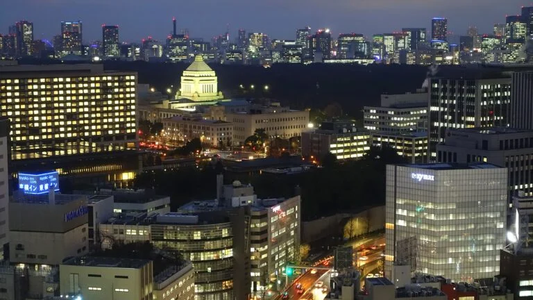 Le bâtiment de la Diète nationale du Japon illuminé la nuit au milieu des immeubles de Tokyo