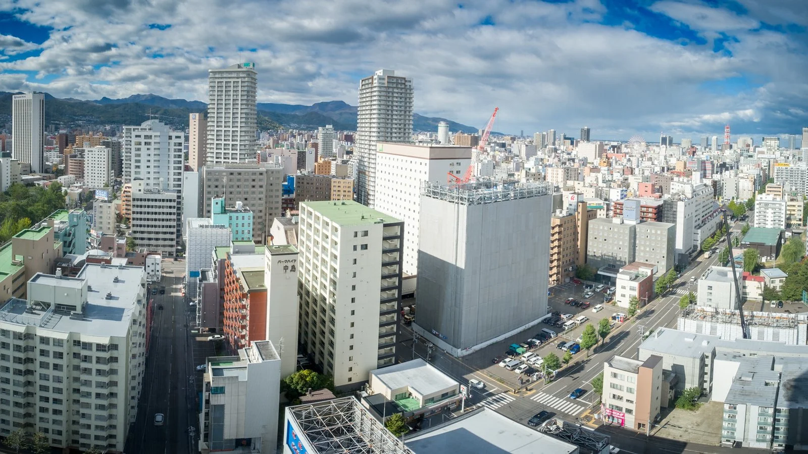 Vue aérienne des immeubles de Sapporo avec les montagnes de Hokkaidō à l'horizon