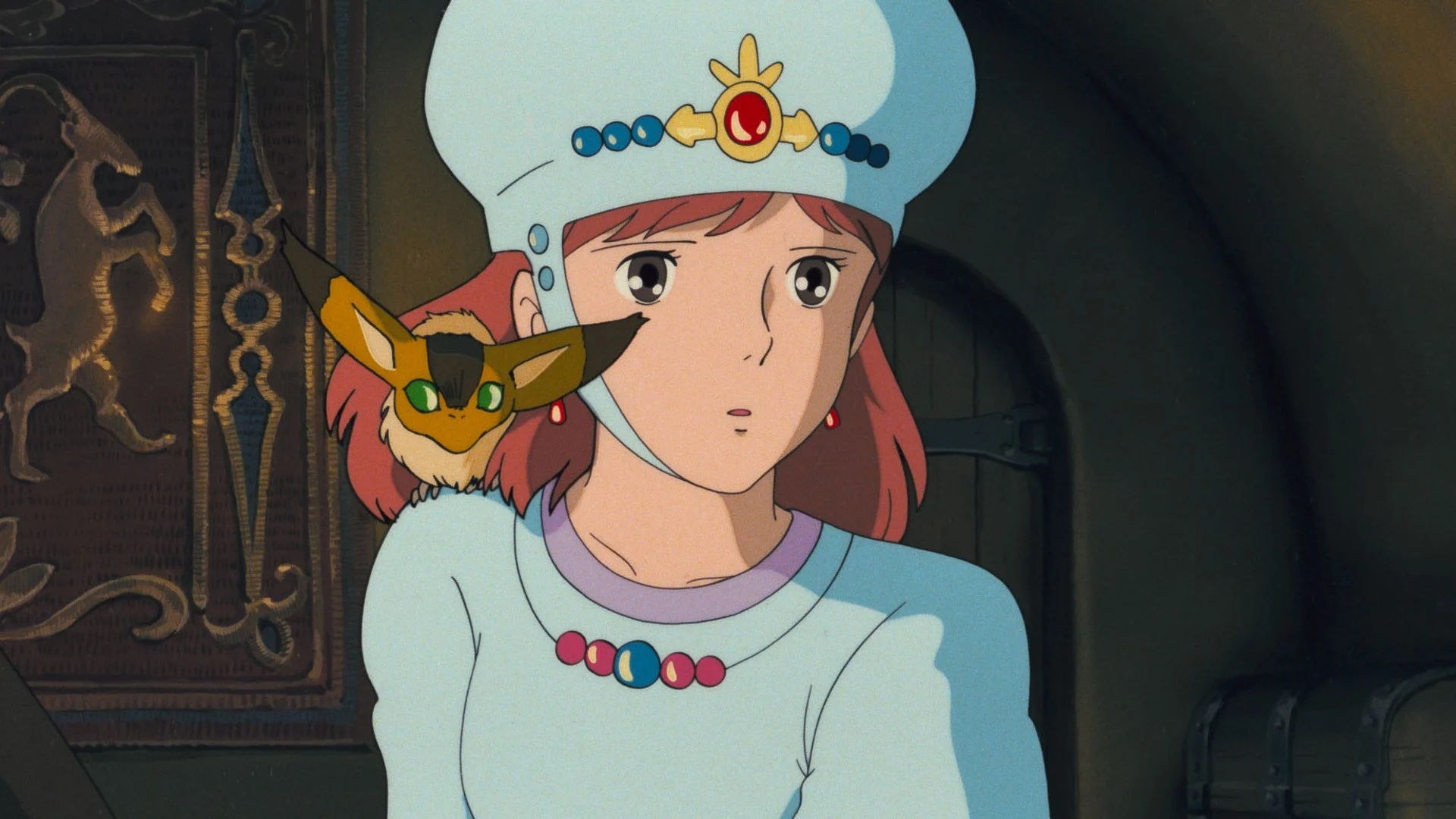 Nausicaä, coiffe bleue ornée d’une pierre rouge, avec Teto sur l’épaule, dans Nausicaä de la Vallée du Vent