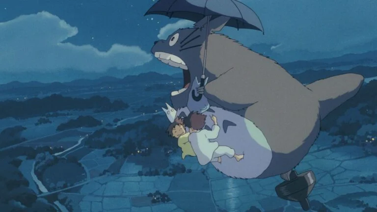 Totoro, son parapluie à la main, s’envole de nuit au-dessus des rizières avec Satsuki et Mei, dans Mon voisin Totoro