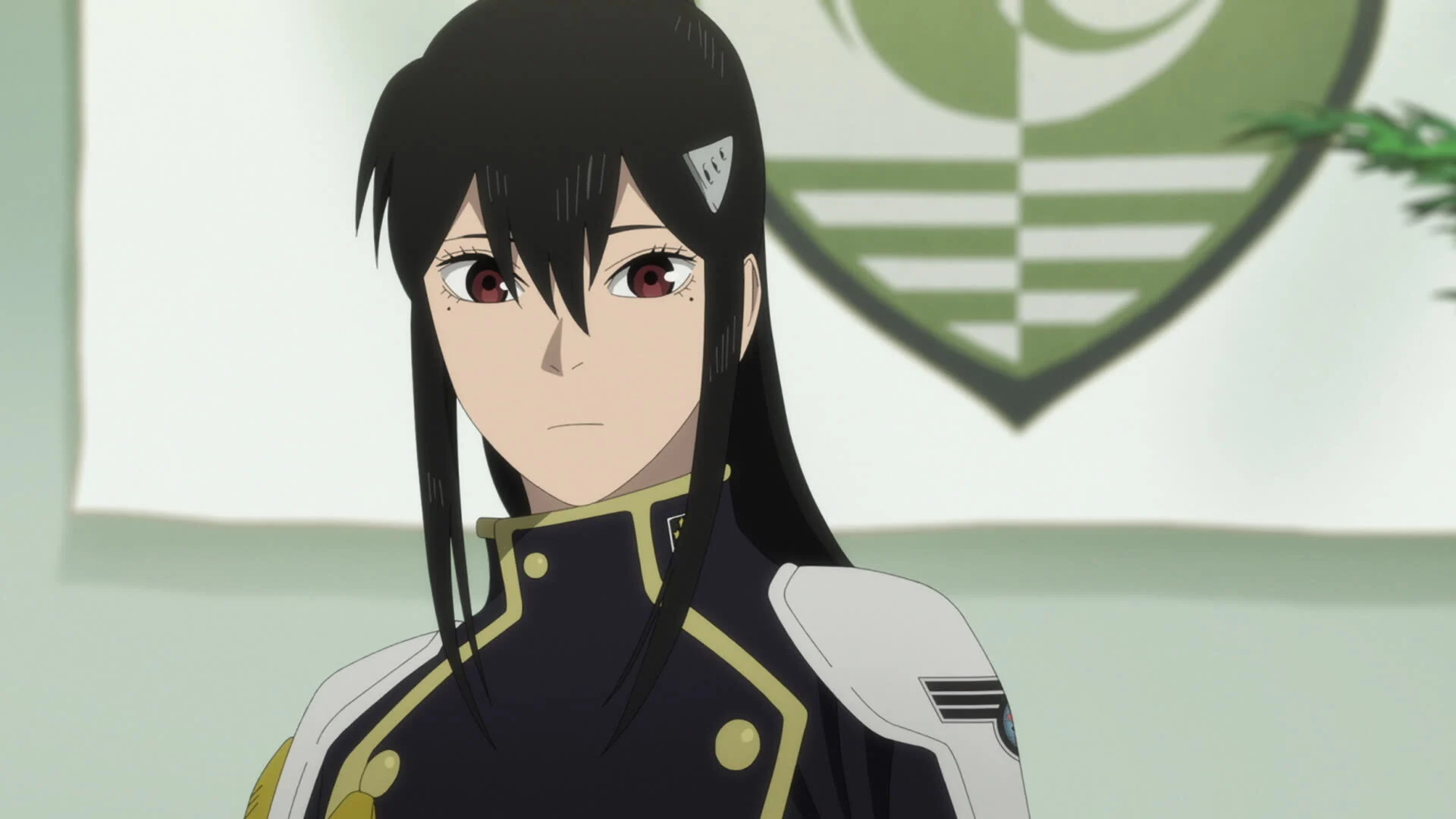 Mina Ashiro, capitaine de la 3e division des Forces de Défense, devant l'emblème de l'unité dans l'anime Kaiju No.8