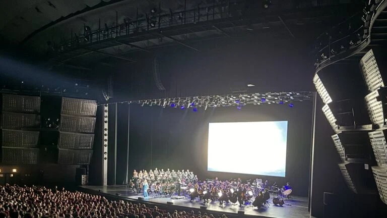 La grande salle du Palais des Congrès de Paris pendant le NieR:Orchestra Concert 12026, orchestre et chœur sur scène sous l'écran géant
